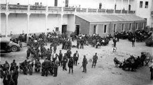 Tropas de Alicante y Murcia armadas vigilan los prisioneros rebeldes desarmados que permacenen sentados en pequeños grupos en el patio del cuartel de Albacete